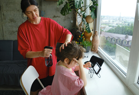 Mother wetting her son's hair before a haircut.