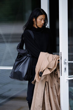 Elegant Woman Exiting a Modern Building in a Stylish Outfit