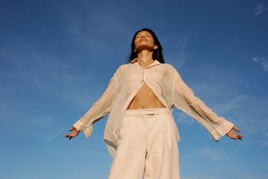 Woman Embracing the Sky in a Serene Moment of Freedom