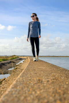 Woman Jogging Along a Coastal Seawall