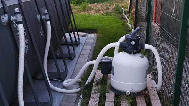 sand filter with a pump for pool water cleaning and circulation near frame swimming pool outdoor