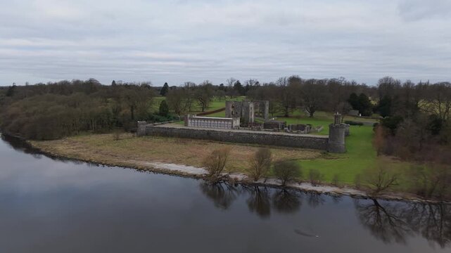 Aerial fly-in across Lough Neagh to the ruins of Shane's Castle and its long stone wall, County Antrim, Northern Ireland