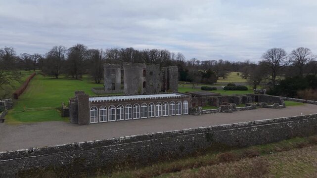 Low aerial push in towards John Nash's camellia house and the ruined tower of Shane's Castle, County Antrim, Northern Ireland