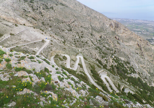 Switchback mountain road leading to Ancient Thera archaeological site on Santorini Greek island, travel and adventure concept