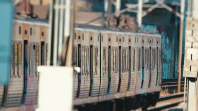 Urban commuter train with graffiti passing by