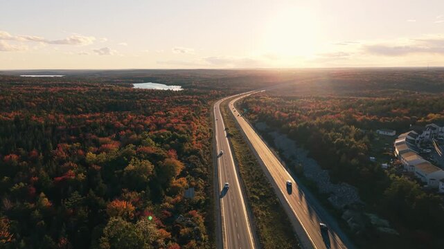 Autumn sunlight traces a highway through the forests and solar fields of nova scotia, canada