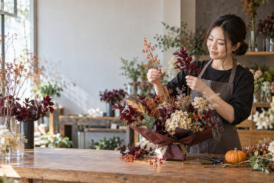 ハロウィンをイメージした秋の花束を作る日本人の花店員