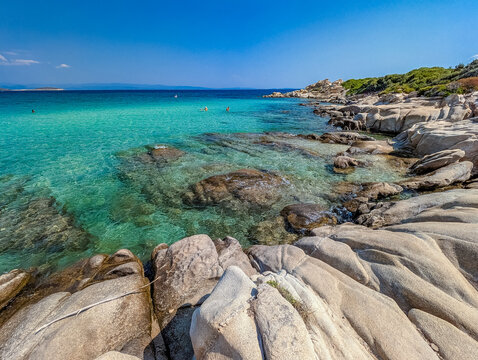 Rocky shoreline and turquoise shallows at Karidi