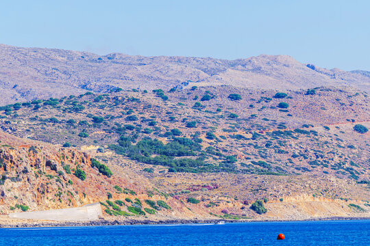 Beautiful view of rocky mountains with shrubs along Mediterranean coast. Crete. Greece.