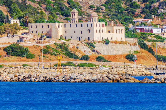 Close up view of coastal monastery overlooking harbor beside Mediterranean Sea. Crete. Greece.