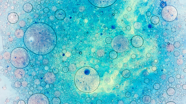 Oil bubbles in water creating abstract blue pattern