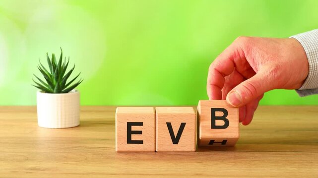 Businessman moves the symbol BEV on BEH. Electric Vehicle Battery vs Electric Vehicle Hydrogen.  Shift from BEV to EVH: instead of long battery charging, instant 3 minute hydrogen fueling.