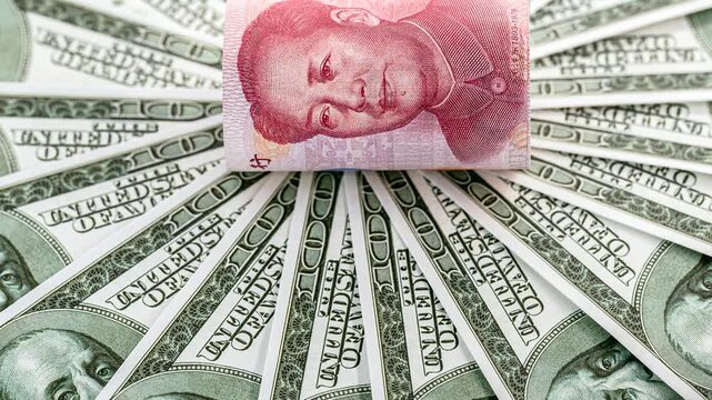 Close-up video of a rolled Chinese one hundred yuan banknote featuring Mao Zedong, surrounded by American one hundred dollar bills arranged in a circular pattern. Symbolizing economic competition betw