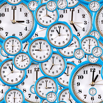 Blue rimmed analog clocks overlapping in a wall display, showing different times indoors. Seamless pattern.
