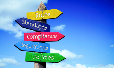 Rules, standards, compliance, regulations, policies - wooden signpost with five arrows, sky with clouds © PX Media