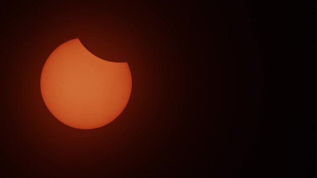 A glowing partial solar eclipse unfolds in the darkening sky above Nova Scotia, Canada, in 2026