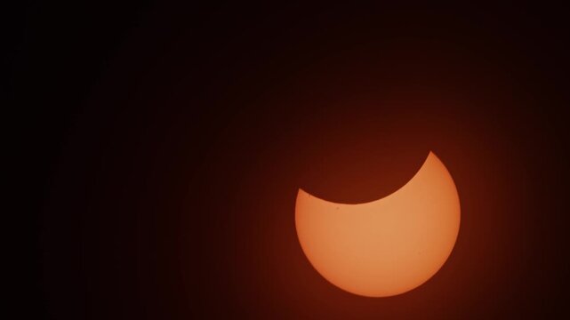 A glowing solar crescent above Nova Scotia as the 2026 eclipse slowly reshapes the bright sun