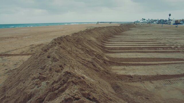 Tall sand berms run along Newport Beach creating a protective wall against high tides and waves.