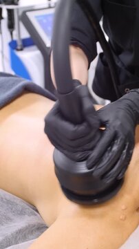 Professional body shaping therapy with vibromassage thermo vacuum and bioelectrical stimulation in beauty salon - vertical video