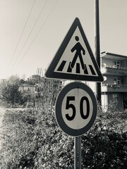 Black and white shot of pedestrian crossing and speed limit traffic signs © Edd