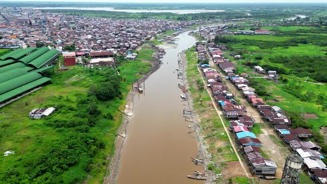 Panoramic aerial view of the traditional riverside district of Belen in Iquitos, showing characteristic stilt houses (palafitos) along the banks of the Itaya River in the Peruvian Amazon.