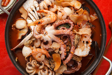 Spicy seafood hot pot with whole octopus crab shrimp abalone and mussels viewed from above © Donghyun Kim