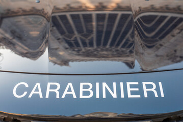 Duomo di milano reflecting on the hood of a carabinieri police car © Ana