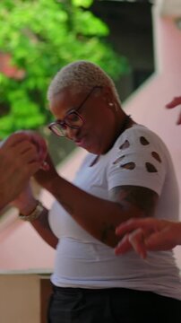 Playful African American woman dancing and pointing outdoors expressing cheerful community joy