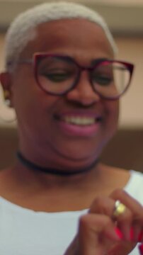 African American woman holding smartphone, engaging with mobile screen