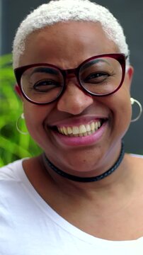 African American woman laughing heartily outdoors, joyful expressive portrait
