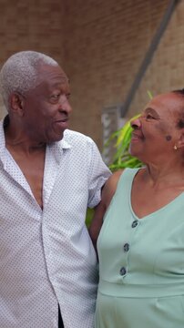 Elderly African American couple looking at each other and smiling outdoors, happy mature couple