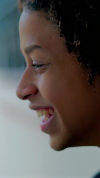 Joyful Hispanic boy of African descent smiling against wall outdoors, feeling happy