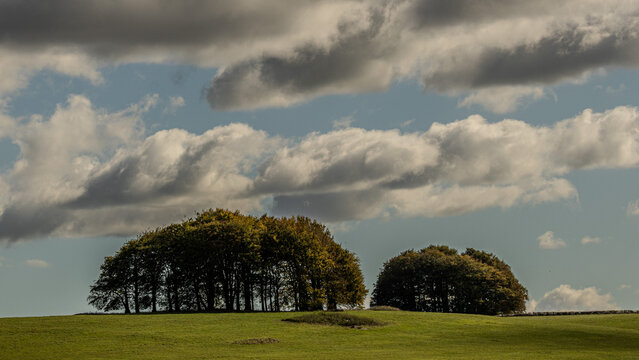 Marlborough Downs in Wiltshire, England. Soft rolling chalk landscape. Ideal for low level arable farming and sheep, goat and cattle grazing on the slopes. Dark menacing clouds formed over the fields.