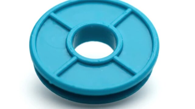 Blue plastic spool bobbin or reel used for industrial sewing and craft projects