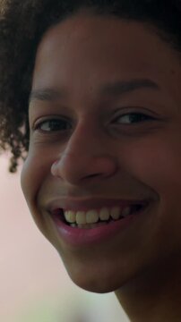 Relaxed Hispanic boy of African descent smiling gently outdoors, feeling peaceful