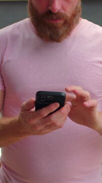 Relaxed man browsing and typing on smartphone outdoors, casual mobile lifestyle