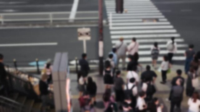 大阪・梅田の交差点を歩く人々をアウトフォーカスで捉えた背景動画