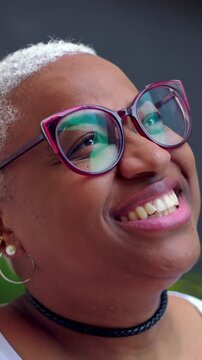 Smiling African American woman looking up outdoors, cheerful expressive portrait