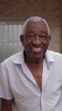 Smiling elderly African American man portrait outdoors, happy senior headshot
