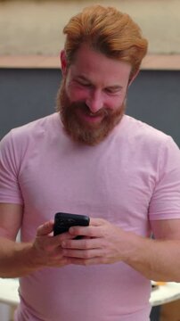 Smiling man showing smartphone with green screen outdoors, positive tech mockup