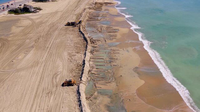 Long Beach, California, USA - October 15, 2026: Tilt up from crews building a sand berm to the Peninsula, defending homes from rising seas and storm surge after Tropical Storm Rachel.