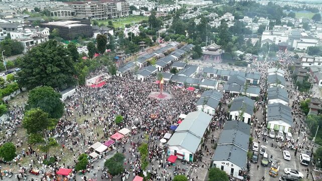 Aerial footage of a crowded town square during the ethnic Torch Festival celebration in summer, Southwest China, D-Log lossless file format