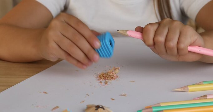 Child using simple prism sharpener at table, closeup