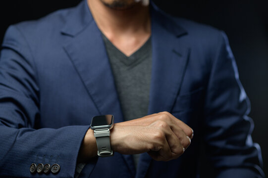 Businessman Checking Time on Smartwatch in Formal Attire in Office Environment