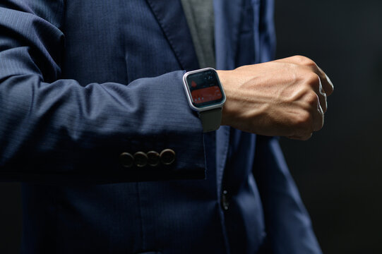 Businessman Wearing Smartwatch Looking at Wrist in Office Setting