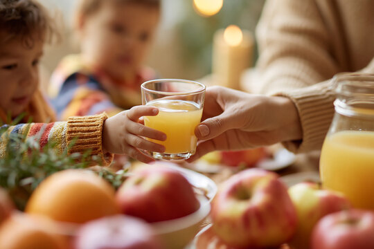 Child reaching for a glass of orange juice during a family breakfast table setting