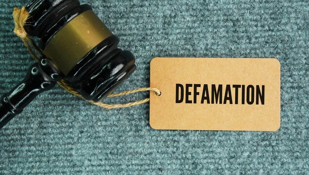 Judge's hammer and paper tag with the word Defamation is a communication that injures a person's or entity's reputation, lowers their estimation in the eyes of others, or exposes them to hatred, conte