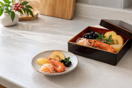 取り分け皿に添えた一段重のおせち料理と正月の食卓と食卓スペースの確認