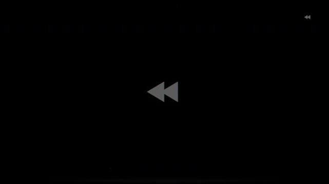 Digital Fast Rewind Icon Flashing on Dark Screen.