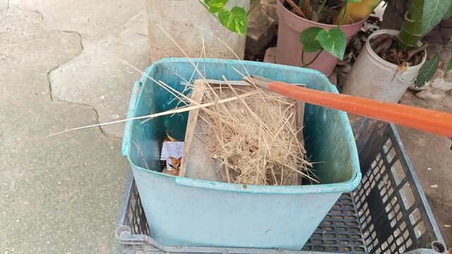 Sweeping Bamboo Wood Shavings into Dustpan